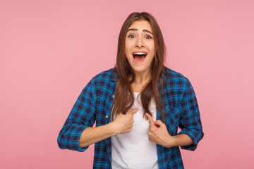 Unbelievable, is it really me? Portrait of excited surprised girl in checkered shirt pointing...