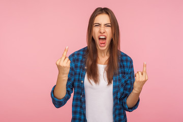 Portrait of enraged vulgar girl in checkered shirt showing middle finger, impolite rude gesture of...
