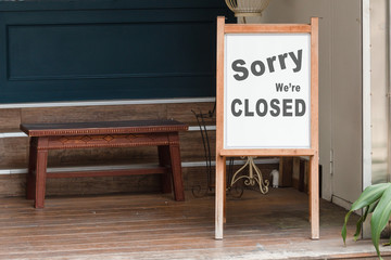 sorry we are closed sign hanging outside a restaurant, store, office or other