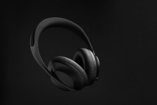 minimalistisches Produktfoto von schwarzen Bluetooth-Kopfh&ouml;rern vor schwarzem Hintergrund