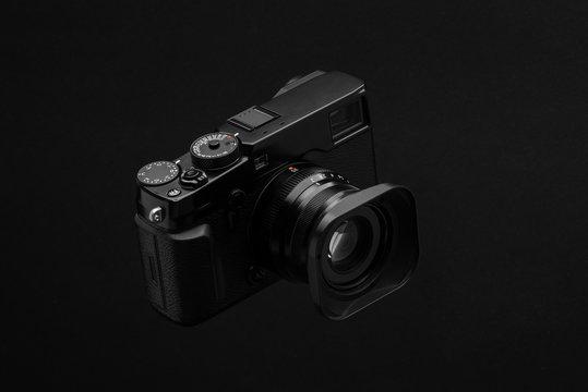 minimalistisches Produktfoto einer schwarzen Digitalkamera vor schwarzem Hintergrund