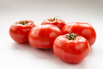 Tomato few vegetables on white background close up vertical. Selective focus. Copy space