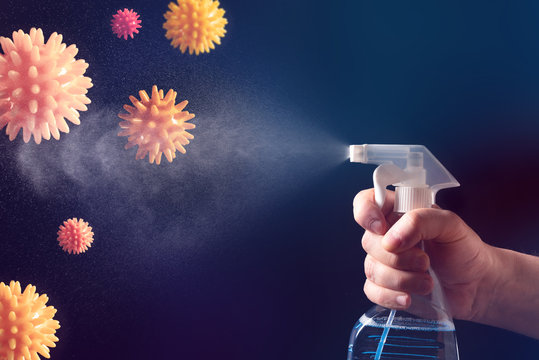 On a dark background, a Hand with a spray bottle. A spray of water. Antibacterial gel for hand disinfection.