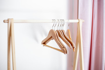 wooden hangers on wooden pole with a white background.