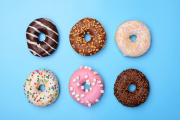 Set of yummy colorful pastel retro summer fashion donuts. Top above overhead flat-lay photo of six beautiful sugary objects isolated over blue background