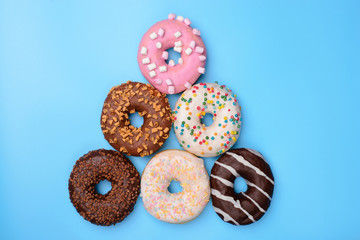 X-mas celebrating concept. Flat lay flatlay top above overhead close up view photo of Christmas tree made of lot of donuts isolated over bright color blue background copy space