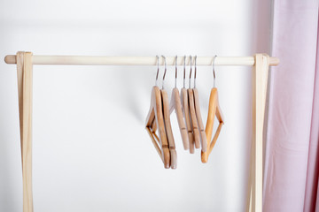 wooden hangers on wooden pole with a white background.