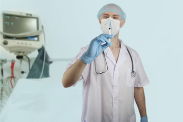 male doctor in defocus with a stethoscope holds a syringe in his hand, the concept of vaccinations from coronavirus, COVID-19, quarantine