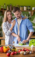 Adorable couple cooking salad with vegetables together