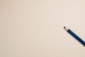 Blue pencil on beige background
