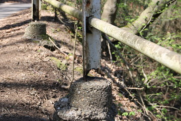 Kaputter Pfeiler am Zaun aus Metall