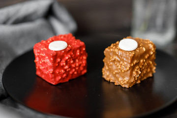 red and brown cakes cupcake with colored chocolate glaze served on a black plate stylish composition with walnut