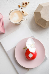 red mousse cake on a pink plate with orchid and coffee © NEZNAEV