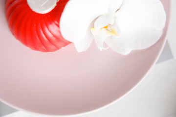 red mousse cake on a pink plate with orchid © NEZNAEV