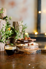 cup of coffee with tiled chocolates and different varieties and nuts