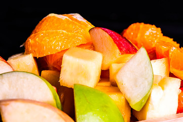 Many fruits are placed in a wooden tray.