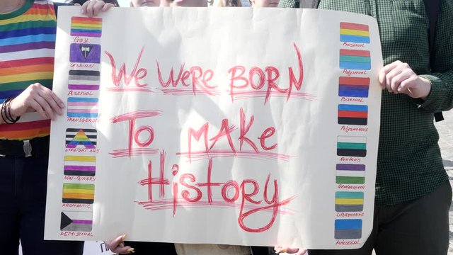 Pride Parade Street Party Celebration with Rainbow flags. Symbol of gay, lesbian, bisexual community. Banner We were born to make history