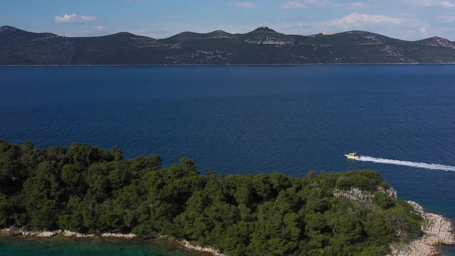 Speed Coast Guard Boat navigating aroung beautiful Island in Adriatic Sea - Aerial Drone View