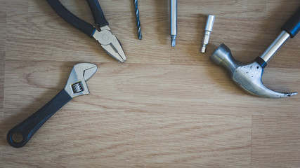 Hammer placed on wooden floor signifying wood work with copy space for your text