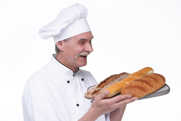 Professional old baker in uniform holding baguettes with bread shelves on white background