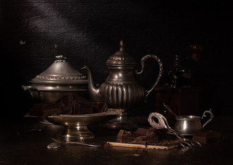 Fototapeta na wymiar Still life with dark chocolate and tin dishes