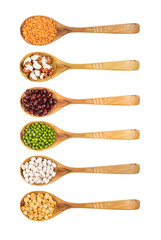Different types of legumes on wooden spoon, white background.