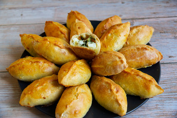 Pies with green onions and eggs in the oven baked