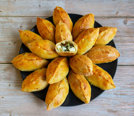 Pies with green onions and eggs in the oven baked