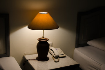 Dark bedroom with one turned on lamp