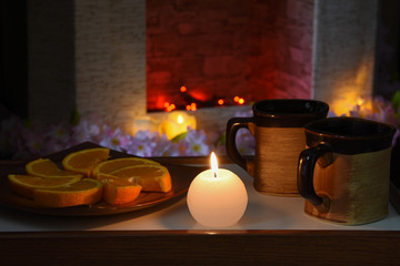 still life with candle, cups and fireplace