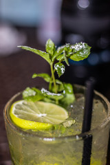 immagine di drink alcolico guarnito con foglioline di menta e lime