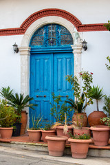 beautiful old blue door with lots of ceramic pots with plants in traditional villages of Cyprus and the Mediterranean