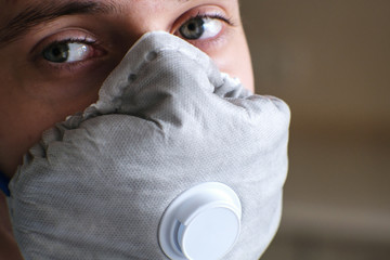 The young man's face is covered by a respirator with an exhalation valve. Designed to protect...