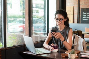 Beautiful woman have coffee in cafe while work in morning freelance, nomad work style use smartphone