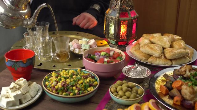 The Islamic holiday of Eid ul-Fitr marks the end of the Islamic fasting of the month of Ramadan. Traditional Eastern food and meal on the table. Muslim family eats together at home