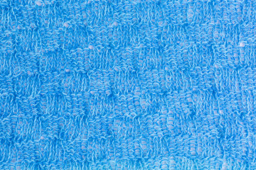 background of knitted fabric in shades of blue in small knitting and purl blocks