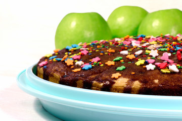 Homemade easter cake on a tray and apples, white wooden background. Paschal cake. Sweet.