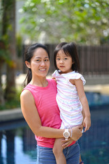 Happy asian chinese mother posing with young daughter
