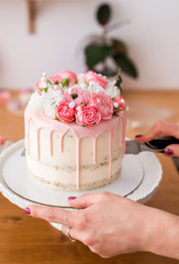 Cut the cake. Close-up of women's hands cutting the cake with a knife.