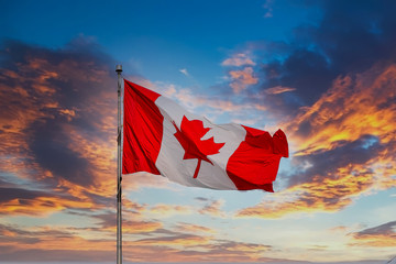 Red and white Canadian Flag Flying at Sunset