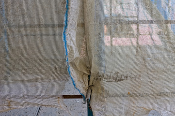 Detail of a scaffolding shielding sheet of a building site (Pesaro, Marche, Italy)