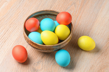 Colorful Easter eggs in brown pottery. Easter eggs are a symbol and a mandatory attribute of Easter.
