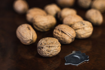 Group of walnuts on a wooden surface with an metallic tool
