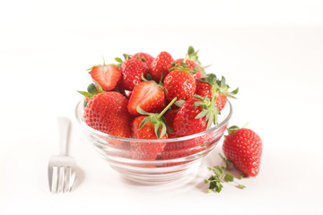 bowl of fresh strawberry and fork on white background