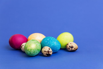 Beautiful multi-colored Easter eggs on a blue background. Religious tradition. Space for text.