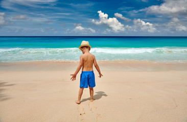 Fototapeta na wymiar Three year old toddler boy walking on beach