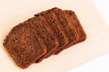 Sliced Russian Borodino brown bread on a white background. Healthy eating and traditions. Close-up. Top view.