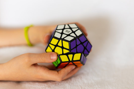 Valladolid, Spain, April 17, 2020: resolution of the rubik's cube (pentagonal version) by the hands of a child. It was invented by the Hungarian architect Erno Rubik in 1974.