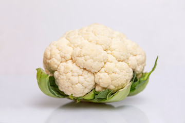A head of fresh cauliflower. Healthy eating and vegetarianism. Close-up. White background.