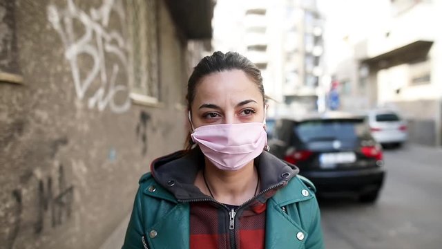 Footage of a young woman wearing a protection mask on her face, as a measure of preventing the spread of Coronavirus (COVID-19).